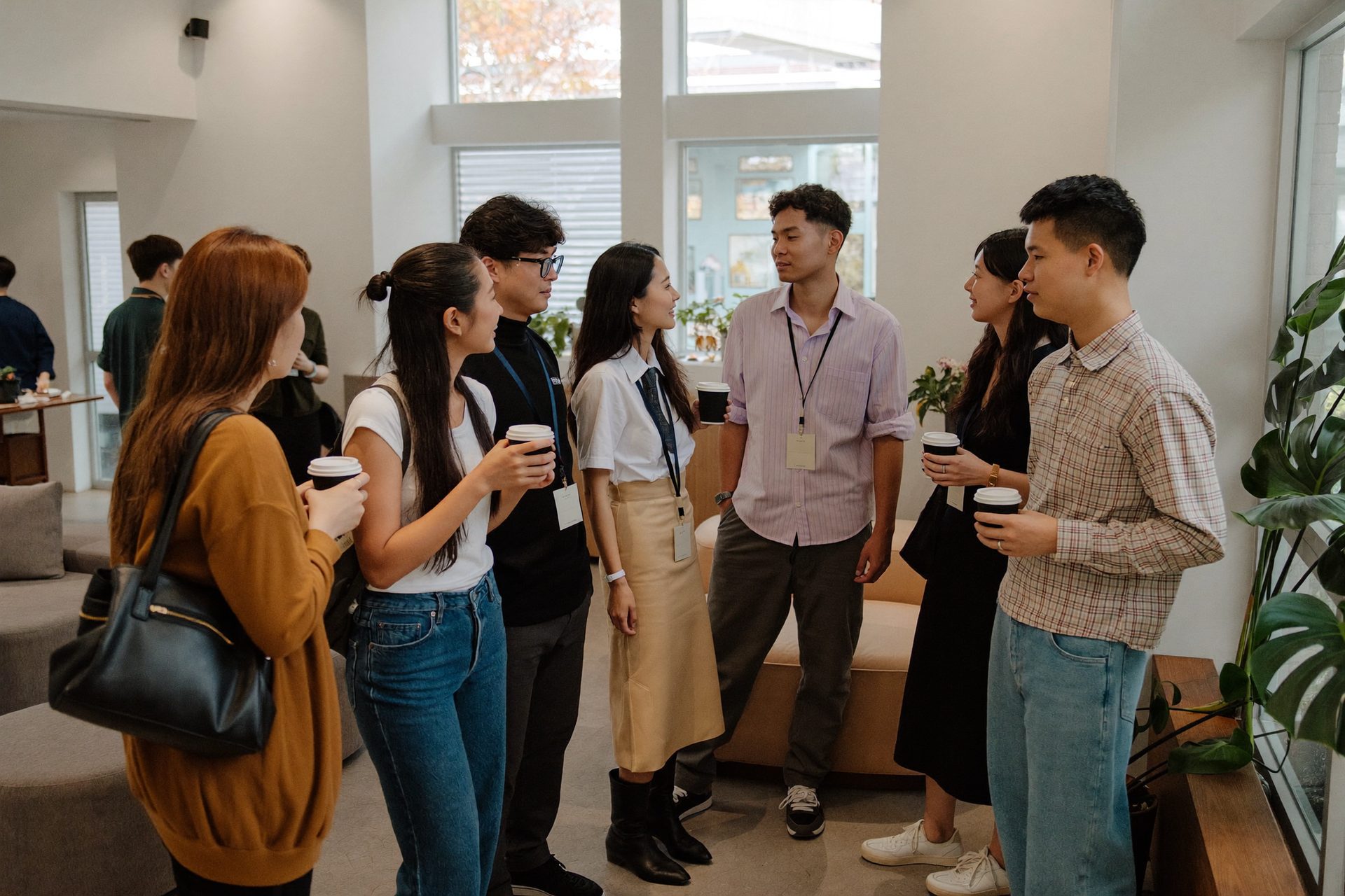 コーヒーを片手に立ち話をする学生たち(イメージ)